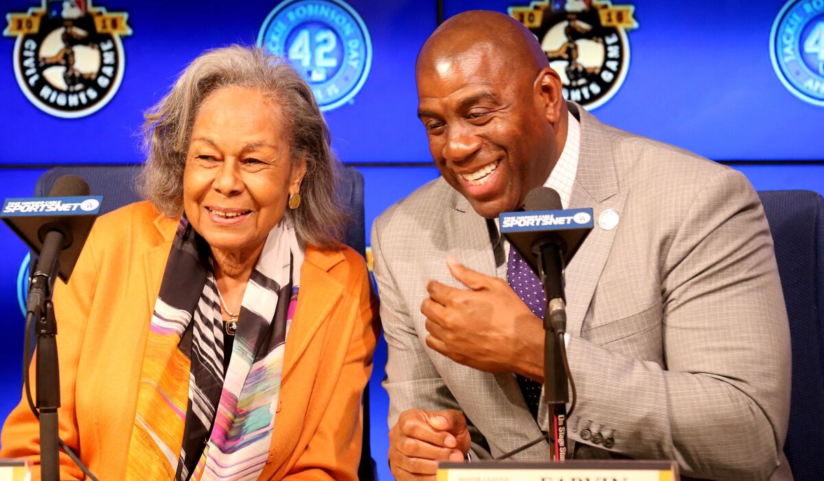 Rachel Robinson, widow of Jackie Robinson, and Dodgers co-owner Magic Johnson share a laugh before a news conference to announce that a statue of her late husband will be erected at Dodger Stadium.