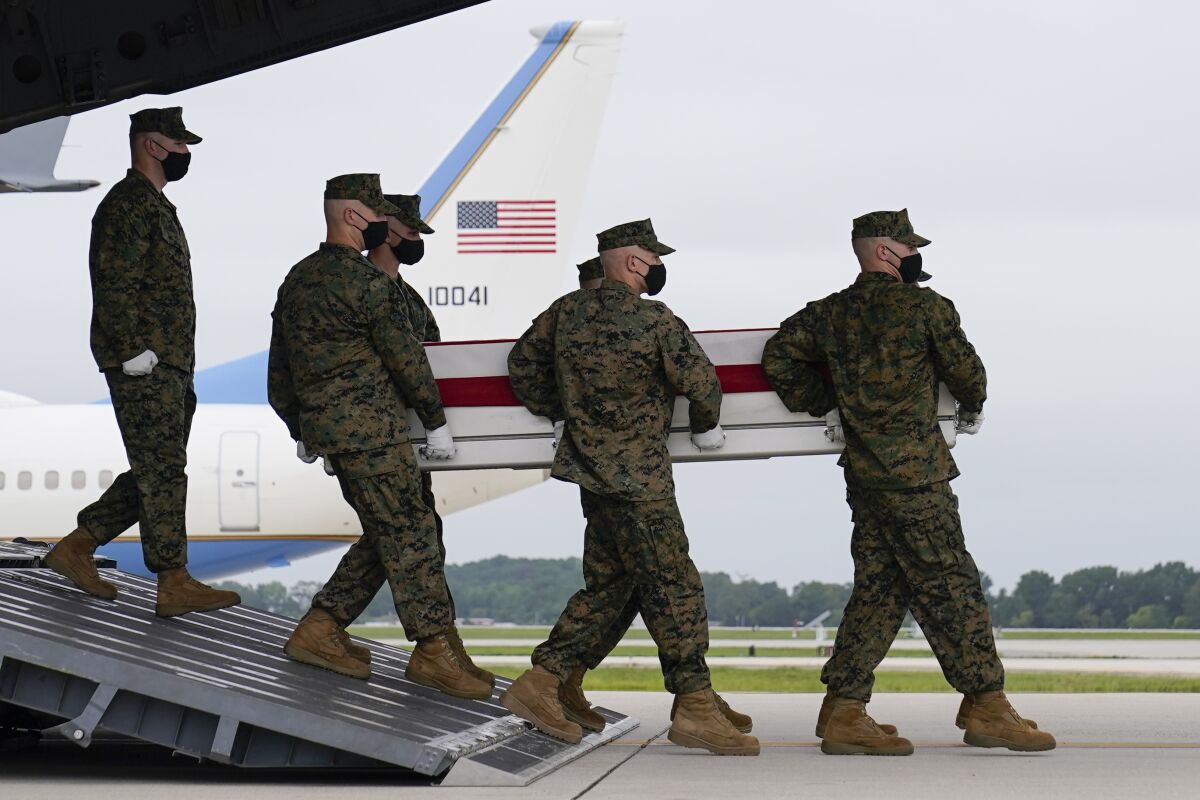 President Joe Biden watches as a carry team moves a transfer case containing the remains of Marine Corps Lance Cpl. Jared M. Schmitz, 20, of St. Charles, Mo., during a casualty return Sunday, Aug. 29, 2021, at Dover Air Force Base, Del. According to the Department of Defense, Schmitz a died in an attack at Afghanistan's Kabul airport, along with 12 other U.S. service members. (AP Photo/Carolyn Kaster)