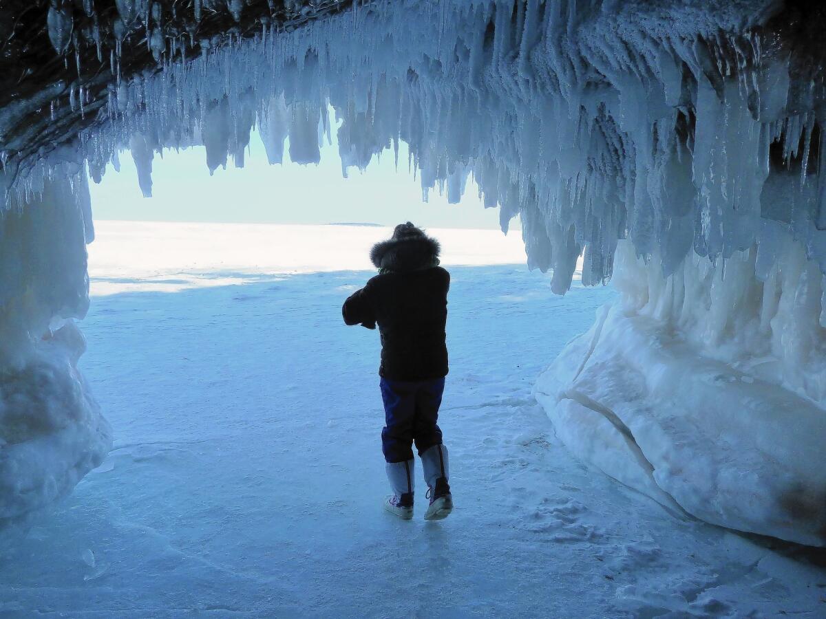Patti Heil of Bloomington, Minn., is among hordes of tourists visiting frozen sea caves near Cornucopia, Wis. The normally inaccessible caves can be reached on foot thanks to a record-setting ice cover on the Great Lakes.
