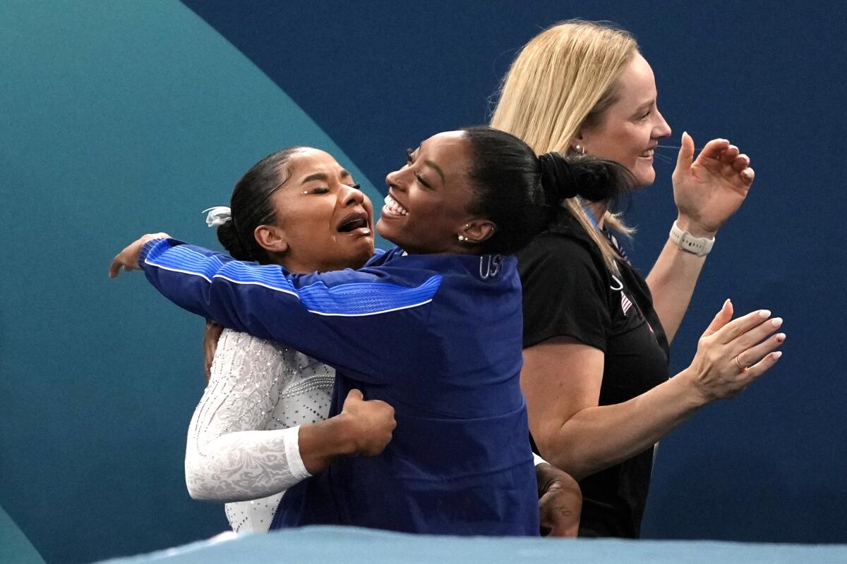 Jordan Chiles, left, gets a hug from teammate Simone Biles after realizing she won the bronze medal 
