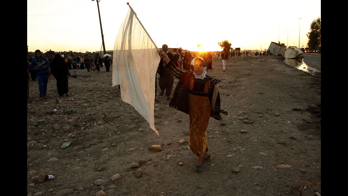 A girl waves a white flag as she and her family leave Gogjali.