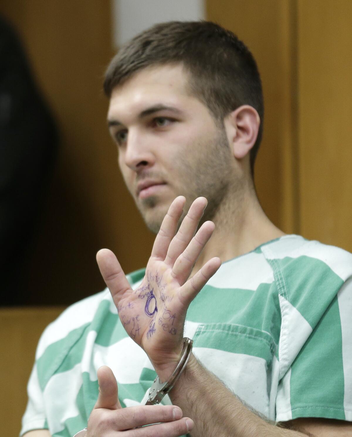Anthony Comello displays writing on his hand during his extradition hearing in Toms River, N.J.