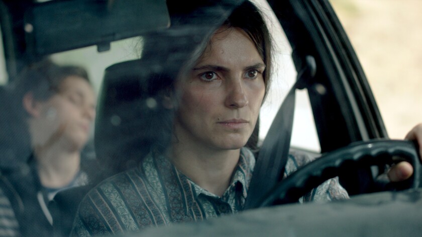 A woman behind the wheel of a car in the movie “Hive.”