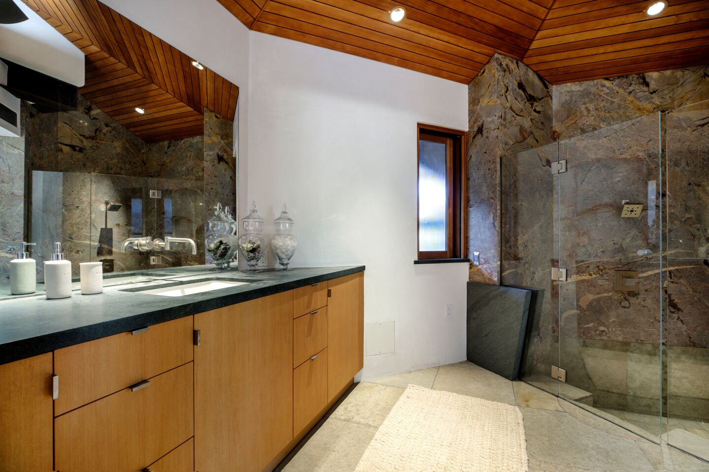 Soaring wood ceilings top a bathroom space in the house.