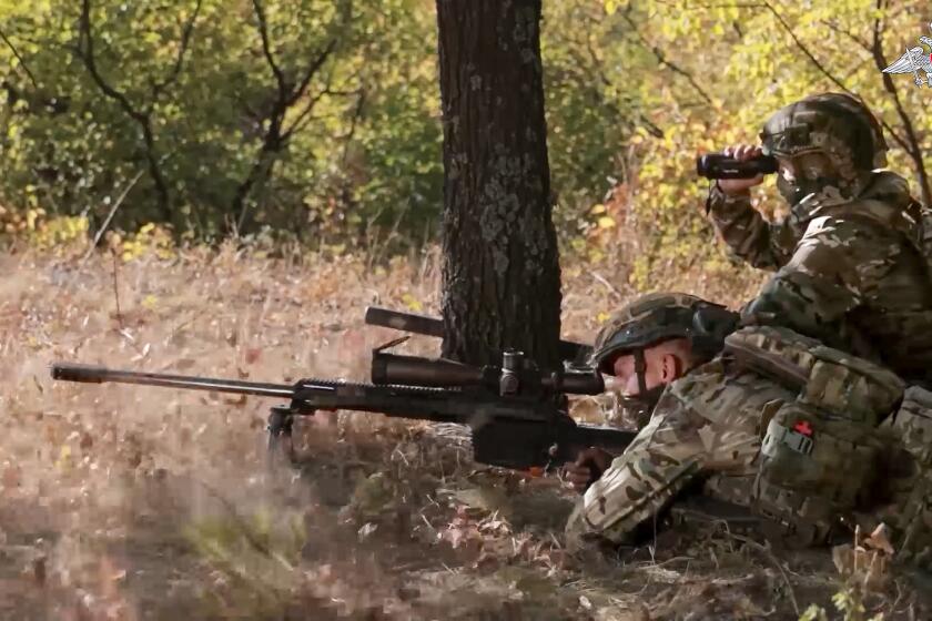 In this image made from video released by the Russian Defense Ministry on Friday, Oct. 11, 2024, a Russian sniper, in an undisclosed location, fires towards Ukrainian forces. (Russian Defense Ministry Press Service via AP)