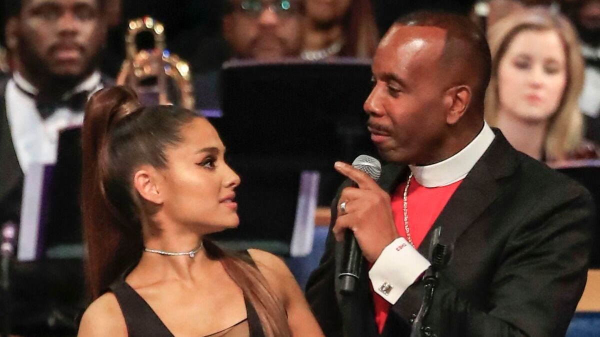 As Bishop Charles Ellis III wrapped his arm around pop star Ariana Grande during the funeral service for Aretha Franklin his fingers rose a little high.