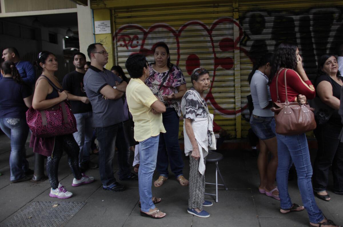 Shoppers stand in line as they wait to enter an appliance store in Caracas, Venezuela, on Monday. President Nicolas Maduro seized control of a nationwide chain of appliance stores Friday seeking to battle inflation and shortages.