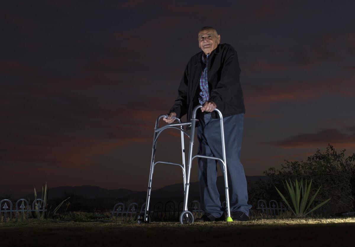 Standing against a desert dusk sky outside his home, Ben Agajanian, 96, is the oldest living member of the Los Angeles Ram on Jan. 15 in Cathedral City, Calif.