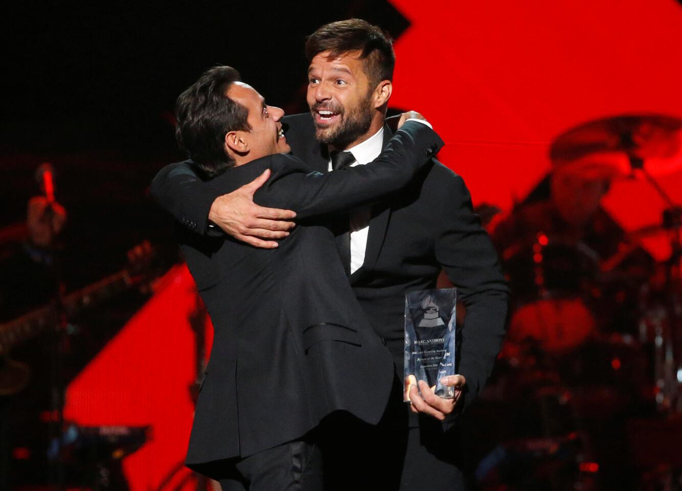 Singer Martin presents recording artist Anthony with the Latin Recording Academy Person of the Year award in Las Vegas
