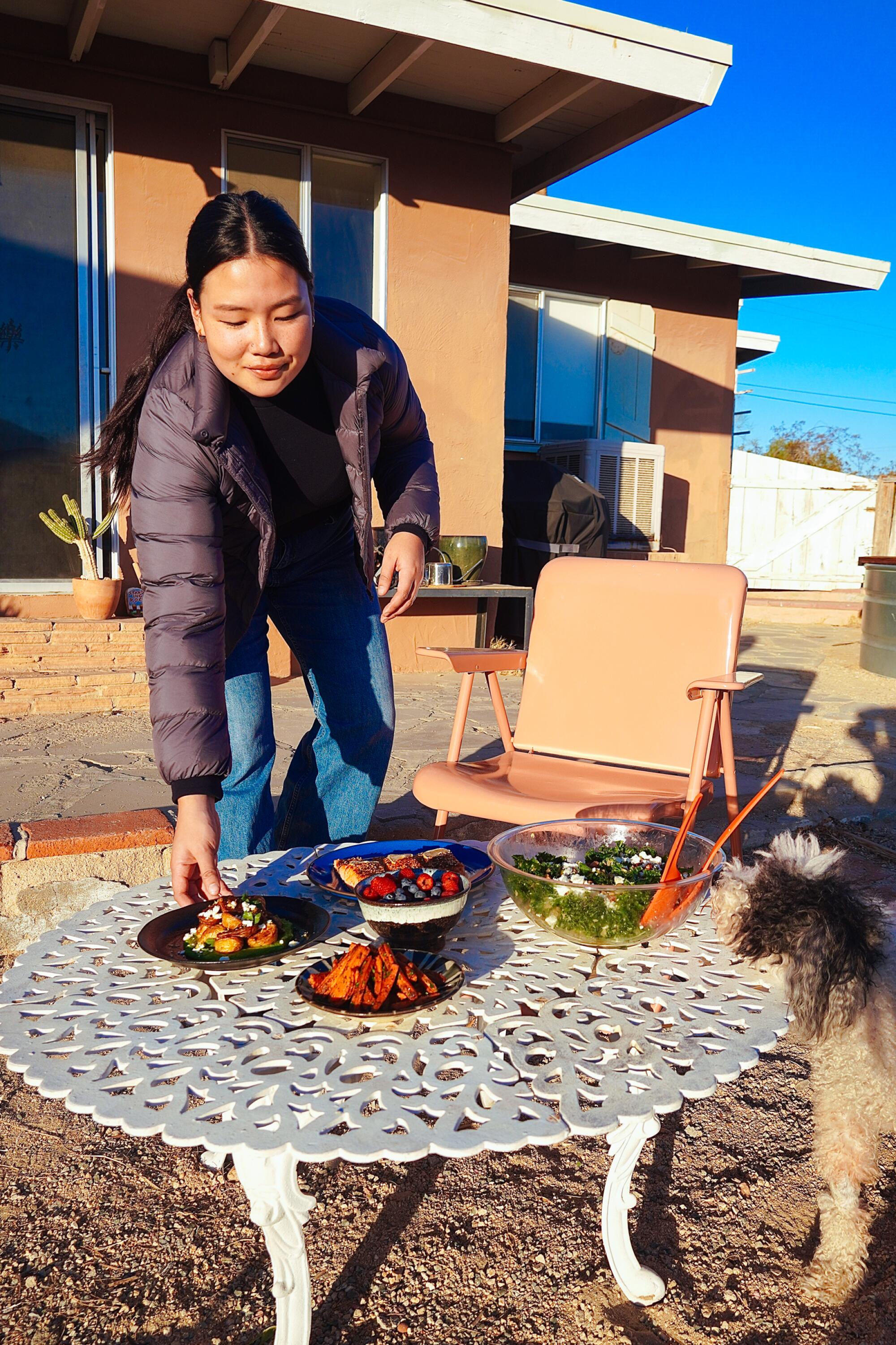 A woman placing a plate down on a table 