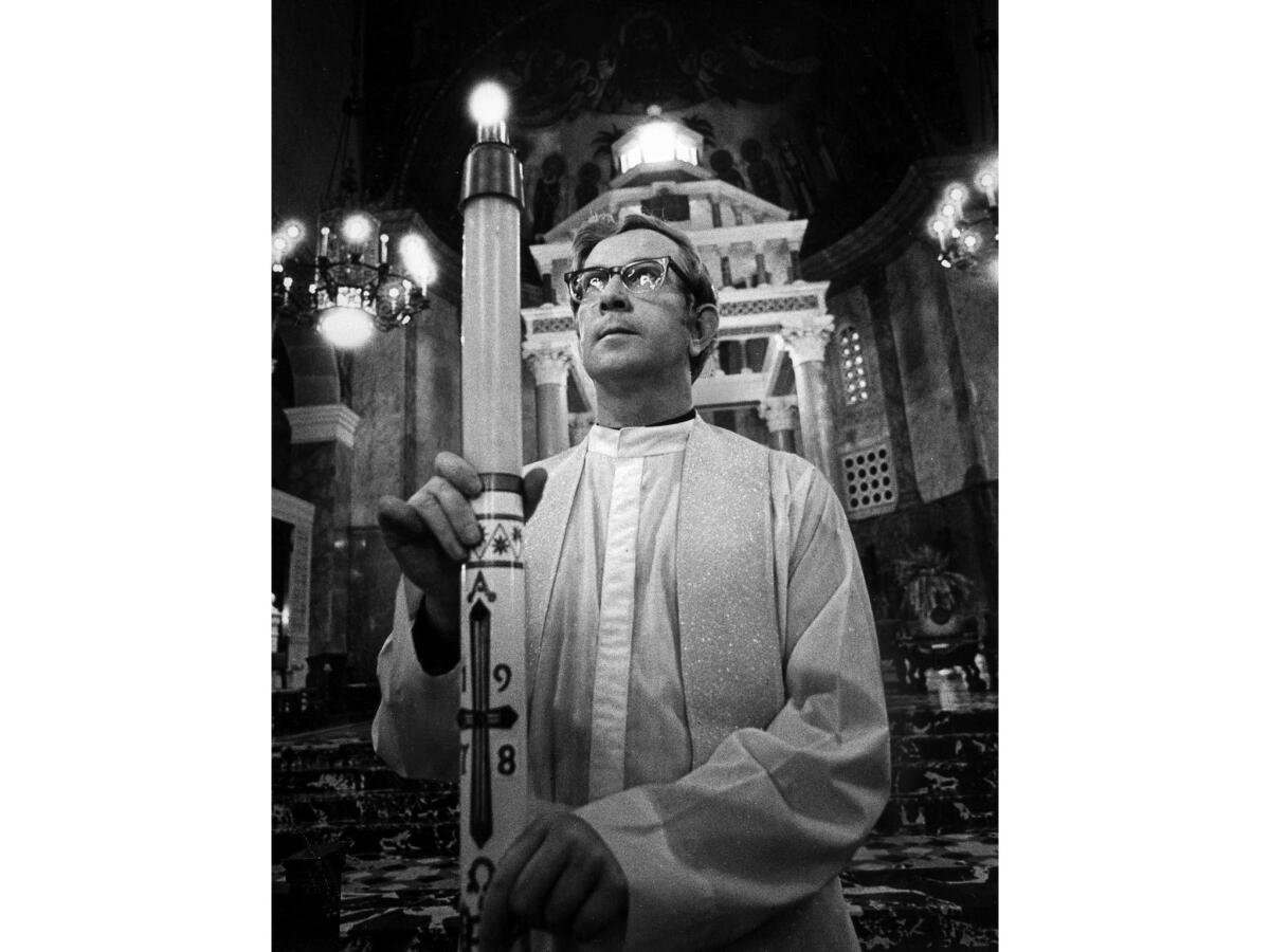 March 22, 1978: Father Joseph Pollard holds a lighted Easter candle in St. Andrew's Church in Pasadena.