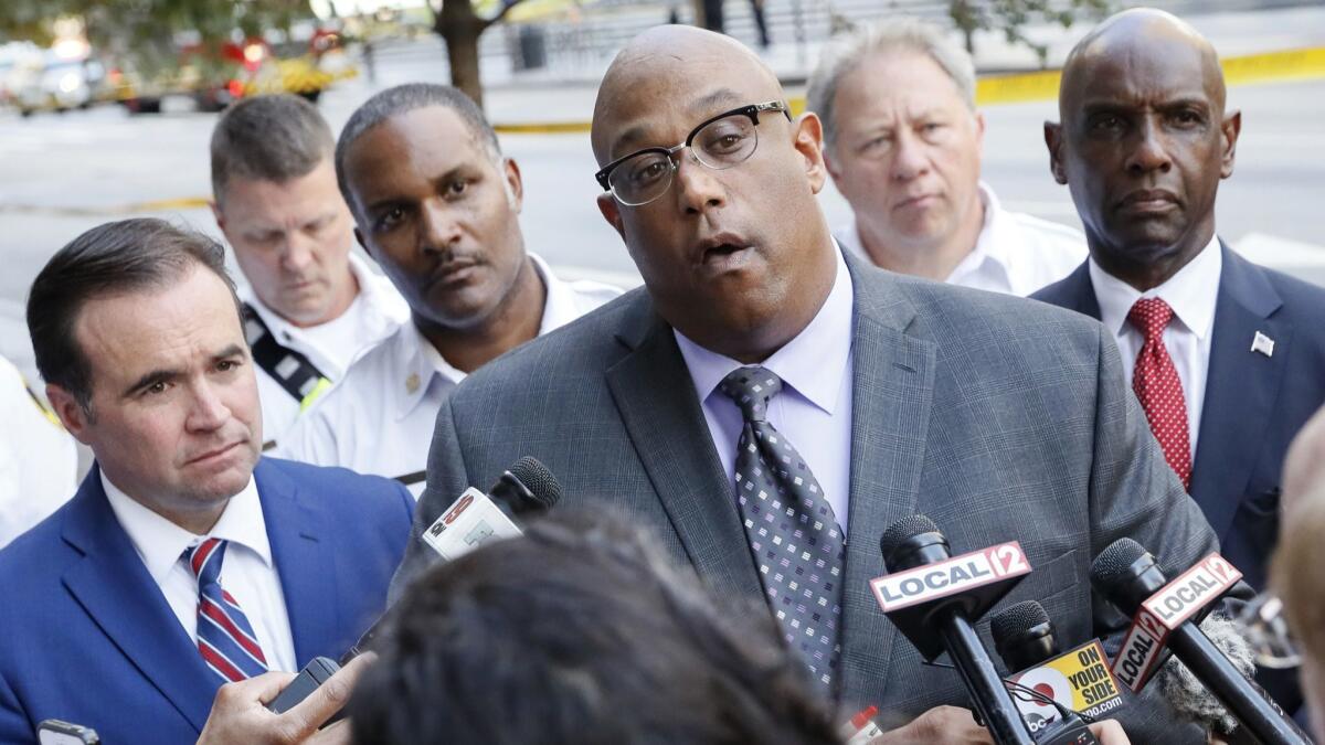 Cincinnati Police Chief Eliot Isaac, center, is joined by Mayor John Cranley, left, and others for a news conference after Thursday's shooting in downtown Cincinnati.