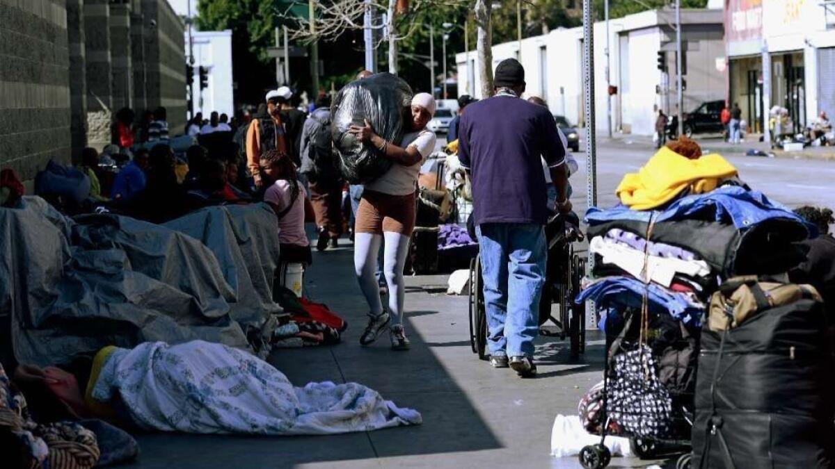Homeless people rest on a sidewalk in the skid row area of downtown Los Angeles in 2013.