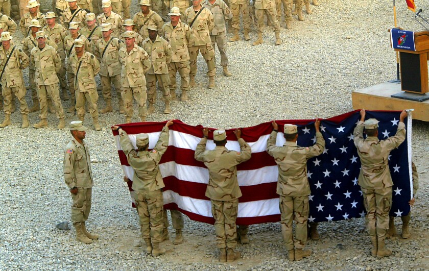 U.S. soldiers participate in a 2002 flag lowering ceremony at Bagram Air Base in Afghanistan 