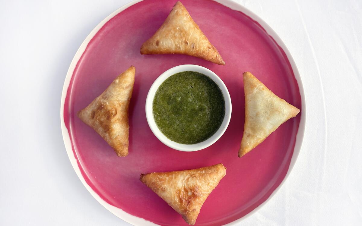 Pacific salmon fills these Somali dumplings, fried until crisp and served with green hot sauce.