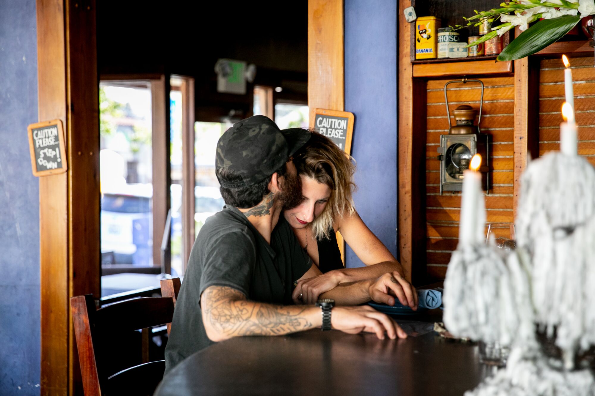 Customers Dan Lopez and Sara Minter share a quiet moment at Bleu Boheme while sitting at the bar as the restaurant reopens in the Kensington neighborhood on May 21, 2020 in San Diego, California. Restaurants began reopening for dine-in patrons on Thursday as the state and county began easing restrictions imposed during the coronavirus pandemic.