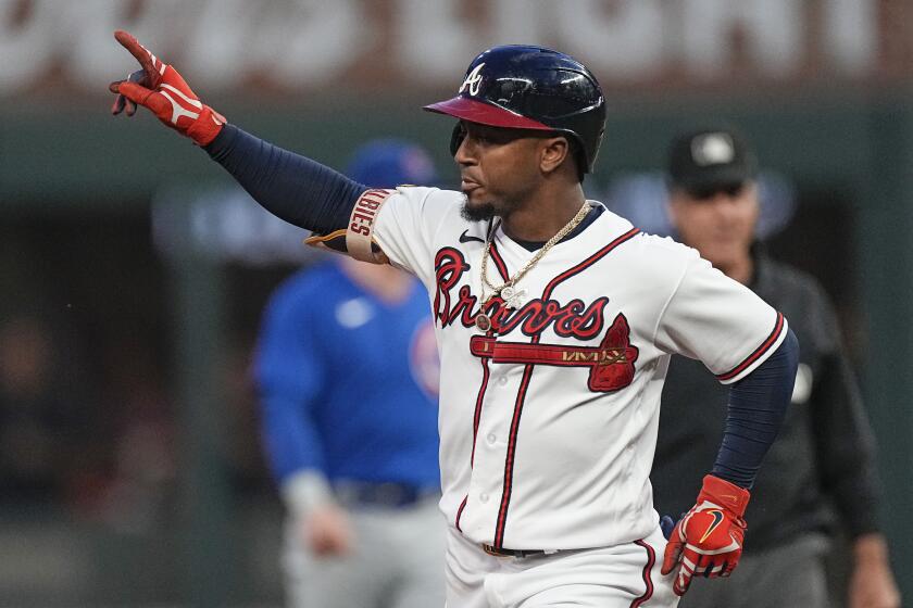 Atlanta Braves' Ozzie Albies gestures as he rounds the bases after hitting a solo home run in the first inning of a baseball game against the Chicago Cubs , Wednesday, Sept. 27, 2023, in Atlanta. (AP Photo/John Bazemore)