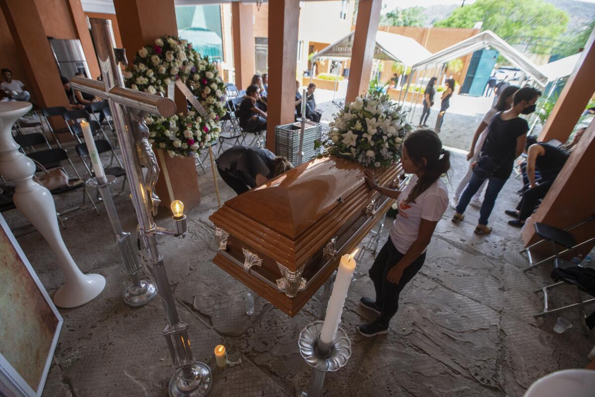A mourner touches a casket.