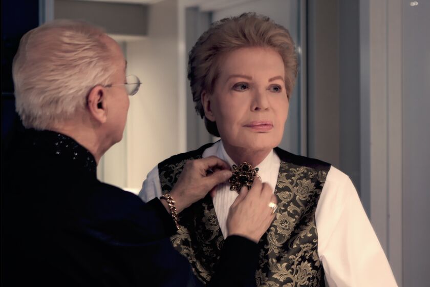 Willie Acosta helps Walter Mercado, the beloved Puerto Rican astrologer, get dressed for an event in Miami.