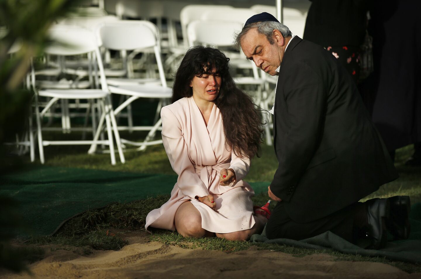 Hannah Kaye, center, kneels with her father Howard at the burial of her mother Lori Gilbert-Kaye, 60, on April 28, 2019 in San Diego, California. Gilbert-Kaye was killed by a gunman at the synagogue.