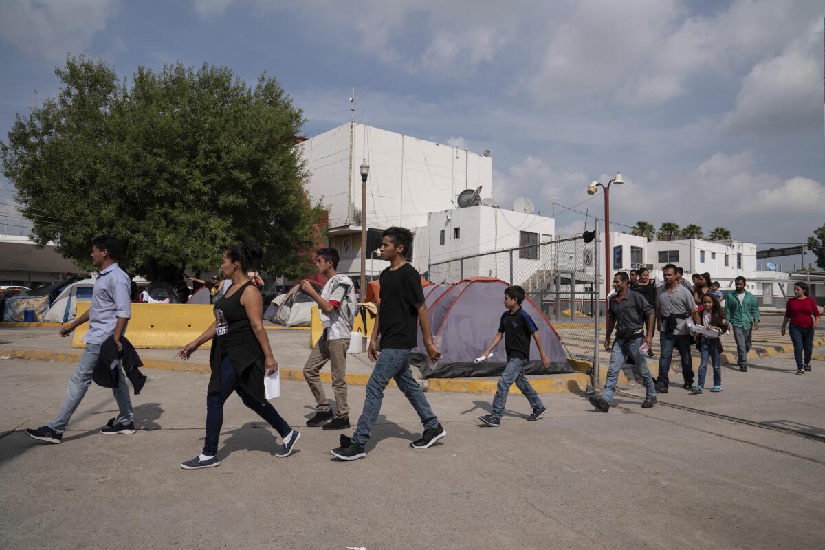 Asylum seekers who have just been sent back from the U.S. to Mexico walk to Human Repatriation facilities on Aug. 24, 2019, in Matamoros.