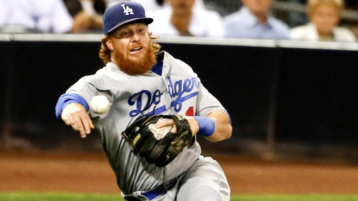 Dodgers third baseman Justin Turner makes an off-balance throw to try to put out a hitter after fielding a bunt during a game against the Padres on Thursday in San Diego.