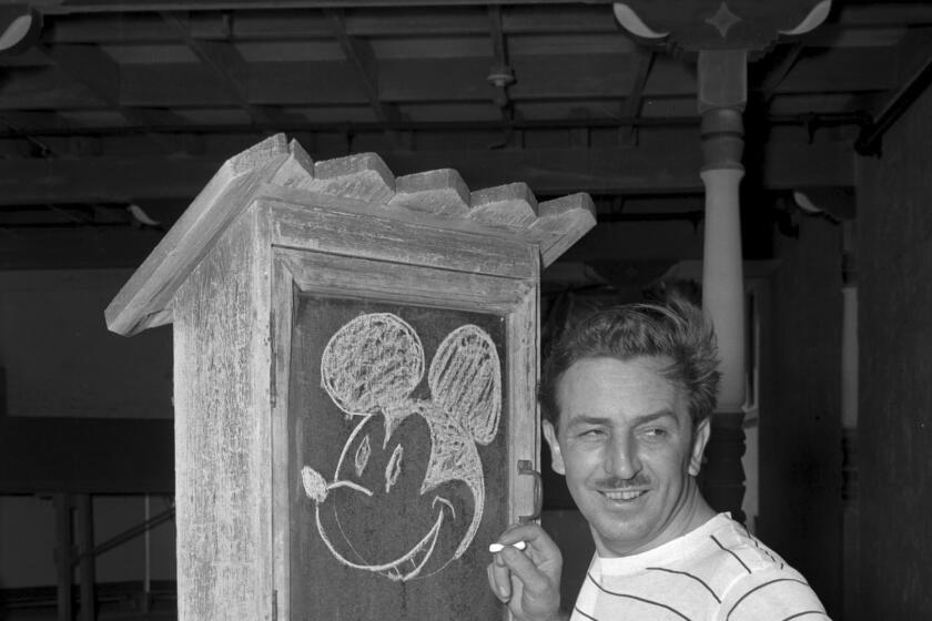 Walt Disney draws Mickey Mouse on a chalk board.