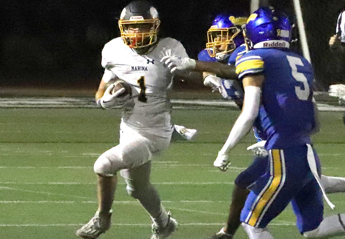 Marina's Gabe Carles (1) runs around Fountain Valley defenders in a nonleague game on Friday at Westminster High.