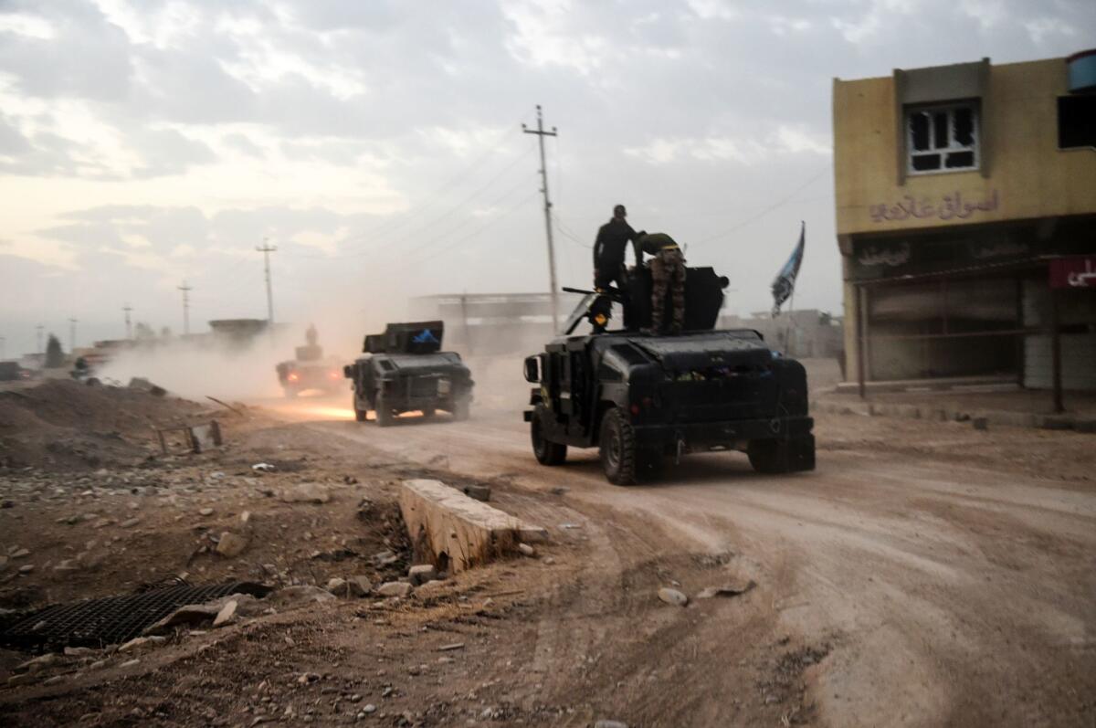 Members of the Iraqi counter-terrorism service drive near the village of Bazwaya, on the eastern edges of Mosul, on Monday.