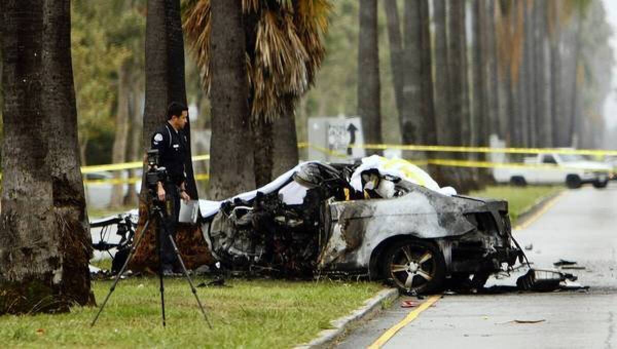 An LAPD officer investigates the scene of a burned out crash that killed journalist Michael Hastings.