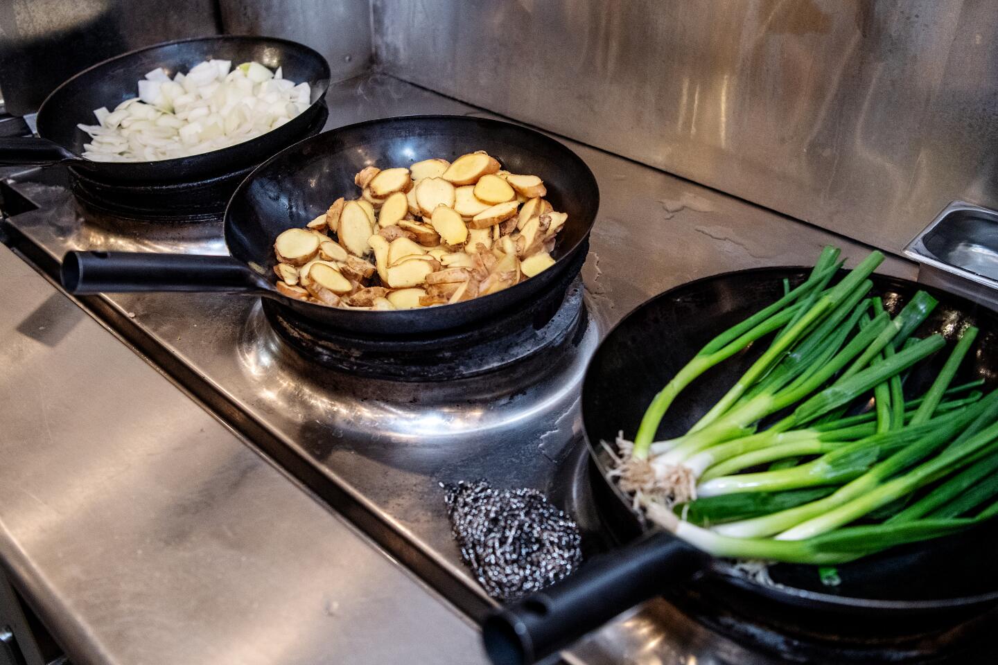 White onions, ginger and green onions are sauted to be added to the pho broth.