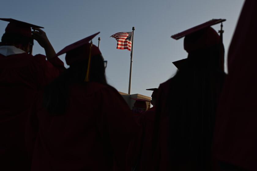 A US flag flies above a building as students earning degrees at Pasadena City College participate in the graduation ceremony, June 14, 2019, in Pasadena, California. - With 45 million borrowers owing $1.5 trillion, the student debt crisis in the United States has exploded in recent years and has become a key electoral issue in the run-up to the 2020 presidential elections. "Somebody who graduates from a public university this year is expected to have over $35,000 in student loan debt on average," said Cody Hounanian, program director of Student Debt Crisis, a California NGO that assists students and is fighting for reforms. (Photo by Robyn Beck / AFP) (Photo credit should read ROBYN BECK/AFP via Getty Images)