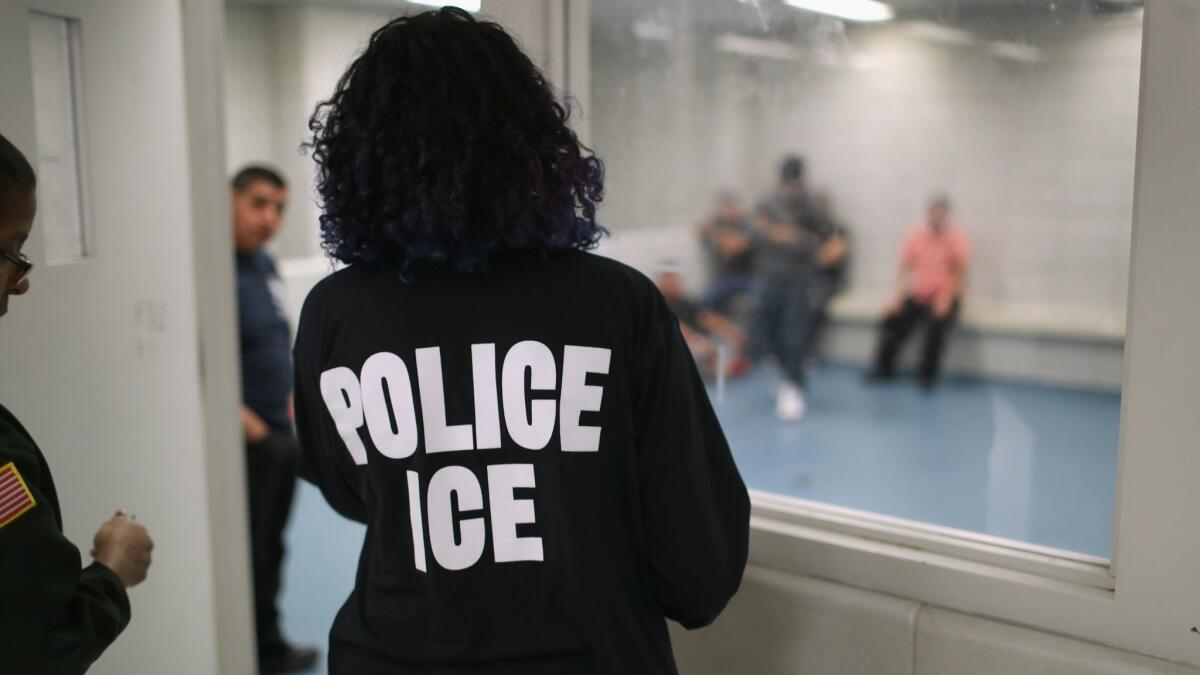 An ICE officer checks on detained immigrants at a holding center in New York on April 11.