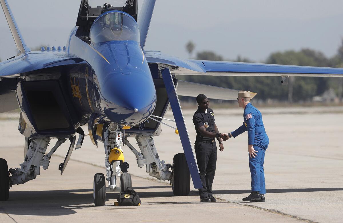 U.S. Navy Blue Angel Pilot Lt. Cmdr. Cary Rickoff greets a member of the ground crew at the 2021 Pacific Airshow.