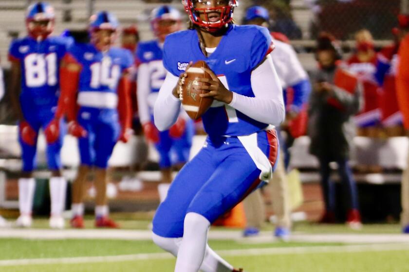 Gardena Serra quarterback Maalik Murphy drops back to pass in the first half of Friday night's game against Long Beach Poly at Cabrillo High.