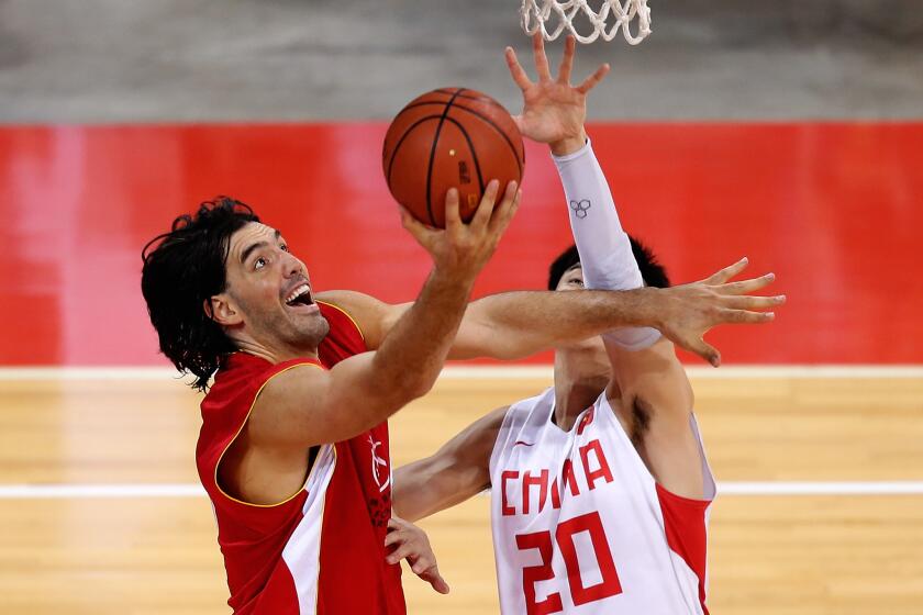 NBA veteran Luis Scola drives to the basket against Ji Zhe of China during the 2013 Yao Ming Foundation charity game on July 1 in Beijing.