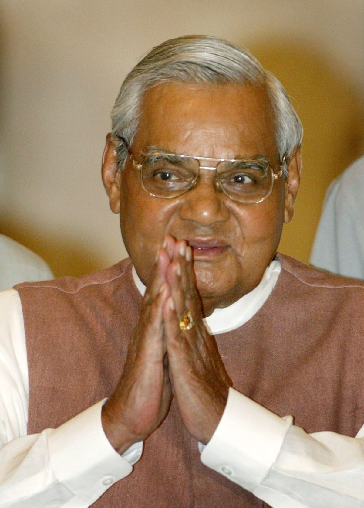 Indian Prime Minister Atal Bihari Vajpayee greets the audience as he arrives for a ceremony at the presidential palace in New Delhi on May 2, 2004.