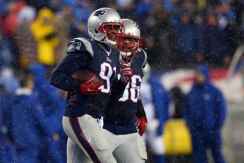 New England linebacker Jamie Collins jogs to the sideline with a football in hand after intercepting a pass from Indianapolis quarterback Andrew Luck on Jan. 18 during the AFC Championship.