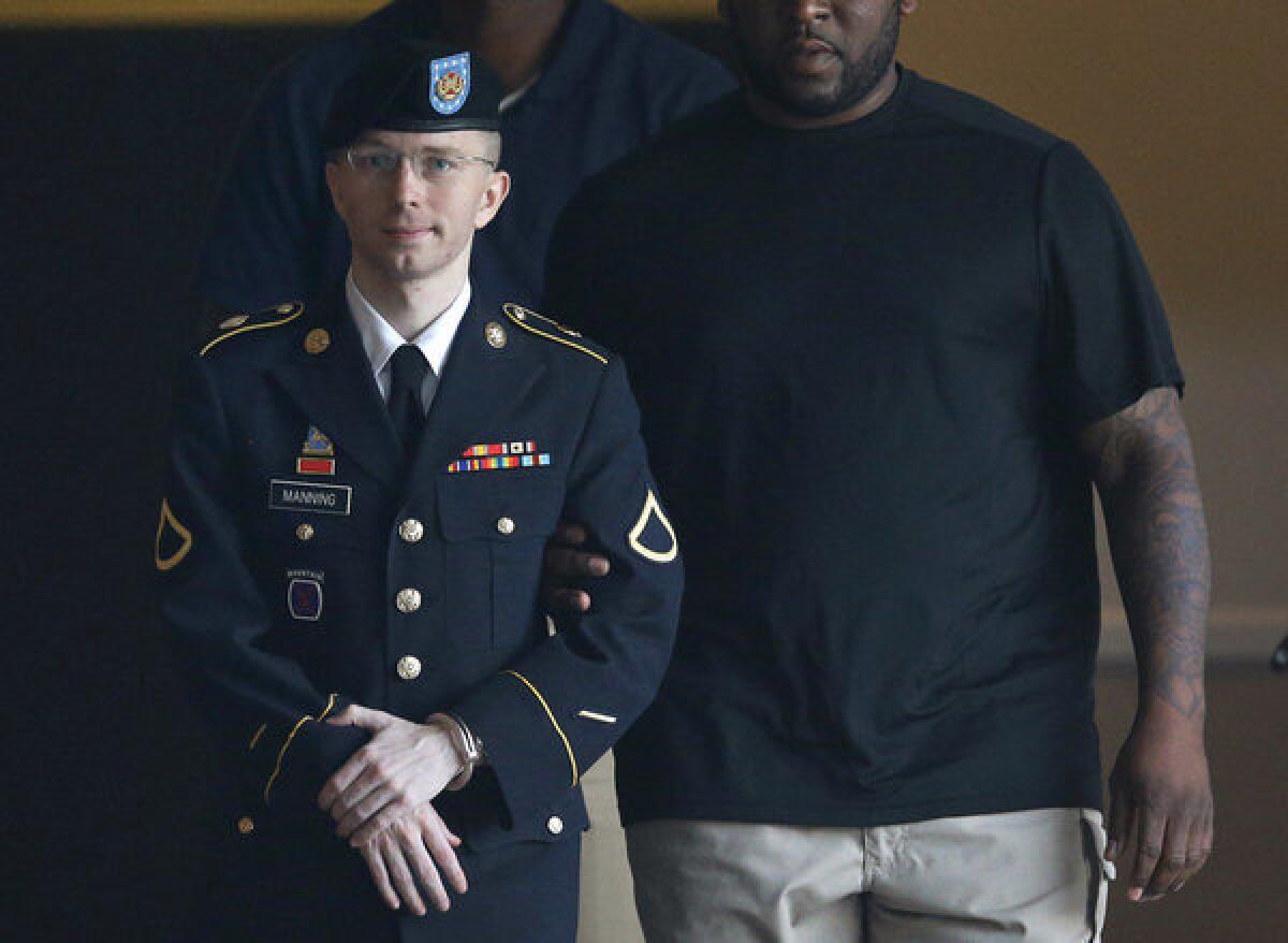 Army Pfc. Bradley Manning is escorted to a waiting security vehicle outside of a courthouse in Fort Meade, Md. after appearing for a hearing at his court martial.