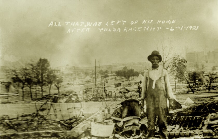 A man stands in front of what's left of his home after the destruction of the Tulsa Race Riots on June 1, 1921.