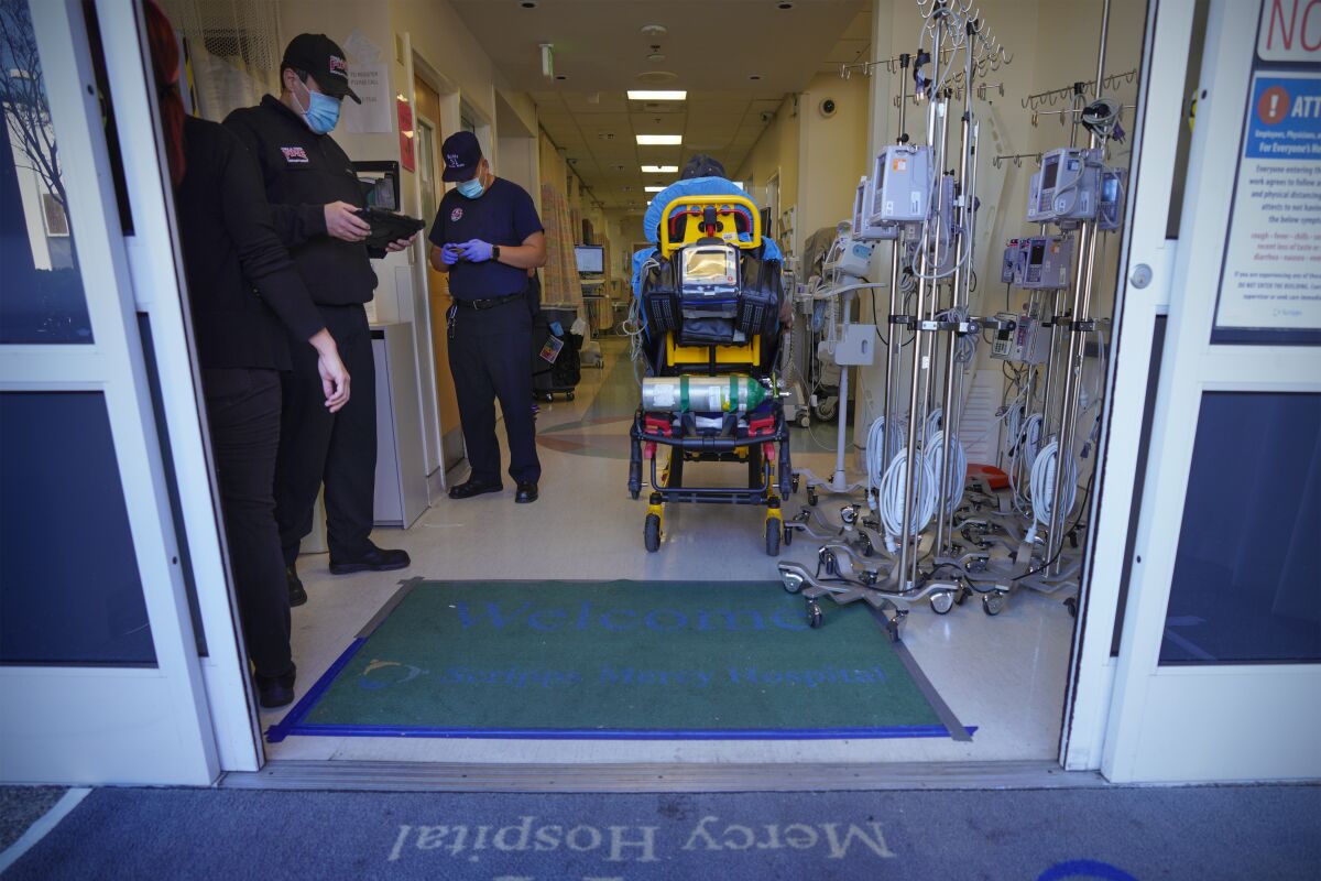 EMTs and paramedics wait at the emergency room door to transfer their patients to Scripps Mercy Hospital Chula Vista.