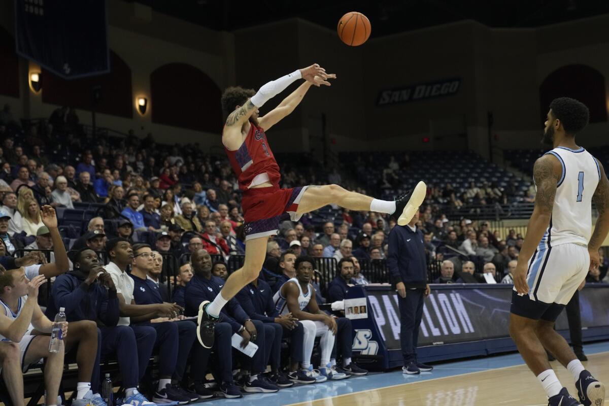 Saint Mary's guard Logan Johnson, left, passes as San Diego guard Jase Townsend (1) looks on during the first half of an NCAA college basketball game Thursday, Feb. 16, 2023, in San Diego. (AP Photo/Gregory Bull)
