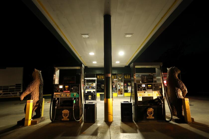 MARIPOSA, CA - APRIL 29, 2020 - - A pair of wooden bear sculptures seem to guard a closed Grizzly Mini Mart and Gas Station along Highway 140 in the heart of Mariposa on April 29, 2020. The gas station is one of the few businesses that is still open during the day in Mariposa. Most of the storefronts have been closed since Gov. Gavin Newsom announced in mid-March that all Californians were being required to shelter in place to reduce the spread of coronavirus. Mariposa County is one of five California counties that as of April 28 only had one reported coronavirus case, despite the fact all the surroundings have. A 23-year-old woman in Marioposa County had tested positive for COVID-190. More than 47,000 Californians have tested positive for the novel coronavirus but in Mariposa County, Tuesday's result was the first. (Genaro Molina / Los Angeles Times)