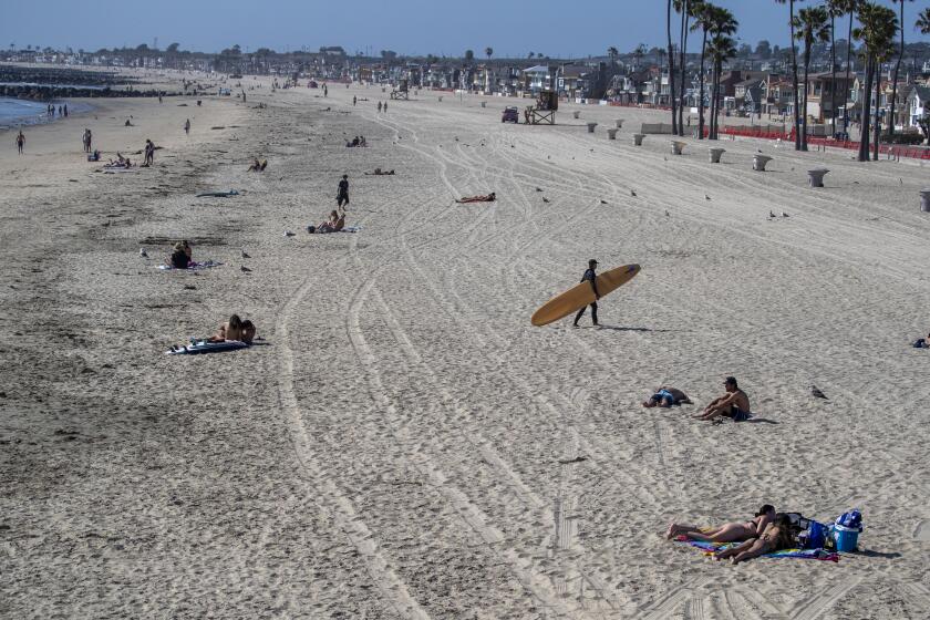 NEWPORT BEACH, CA -- MONDAY, MAY 4, 2020: Beach-goers spread out across the beach while enjoying a nice day at the beach despite Gov. Gavin Newsom's hard closure, which is still in place in Newport Beach, CA, on May 4, 2020. (Allen J. Schaben / Los Angeles Times)