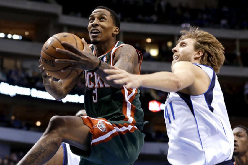 Bucks point guard Brandon Jennings gets past Mavericks power forward Dirk Nowitzki for a layup in a game last month at Dallas.