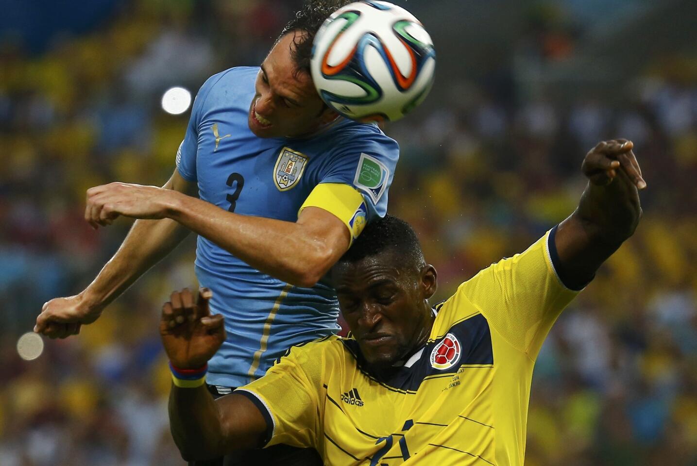 Uruguay's Godin fights to head the ball with Colombia's Martinez during their 2014 World Cup round of 16 game at the Maracana stadium in Rio de Janeiro