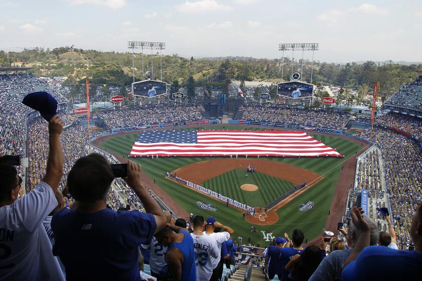 LOS ANGELES-CA-APRIL 12, 2016: An America flag covers the field during the national anthem at Dodger Stadium on Opening Day. (Christina House / For The Times)