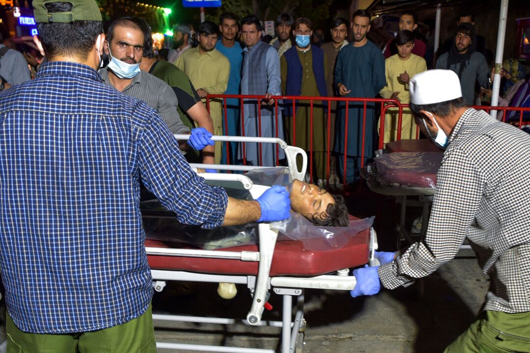 Volunteers and medical staff bring an injured man on a stretcher to a hospital 