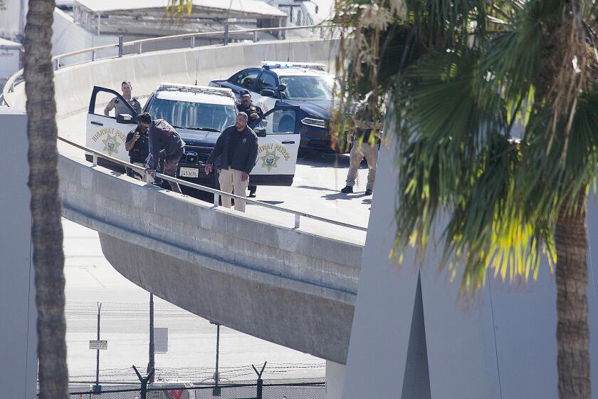 LOS ANGELES, CALIF. - OCT. 20, 2022. A man threatens to jump off of an overamp after leading police on a car chase from San Diego to the Los Angeles International Airport on Thursday afternoon, Oc t. 20, 2022. The suspect held officers at bay on the. Sepulveda Boulevatd offramp to the airport or more than an hour before surrendering peacefully. The incident caused a massive traffic jam on the northbound lanes of the Sepulveda tunnel as it runs beneath the tarmac towards LAX. (Luis Sinco / Los Angeles Times)