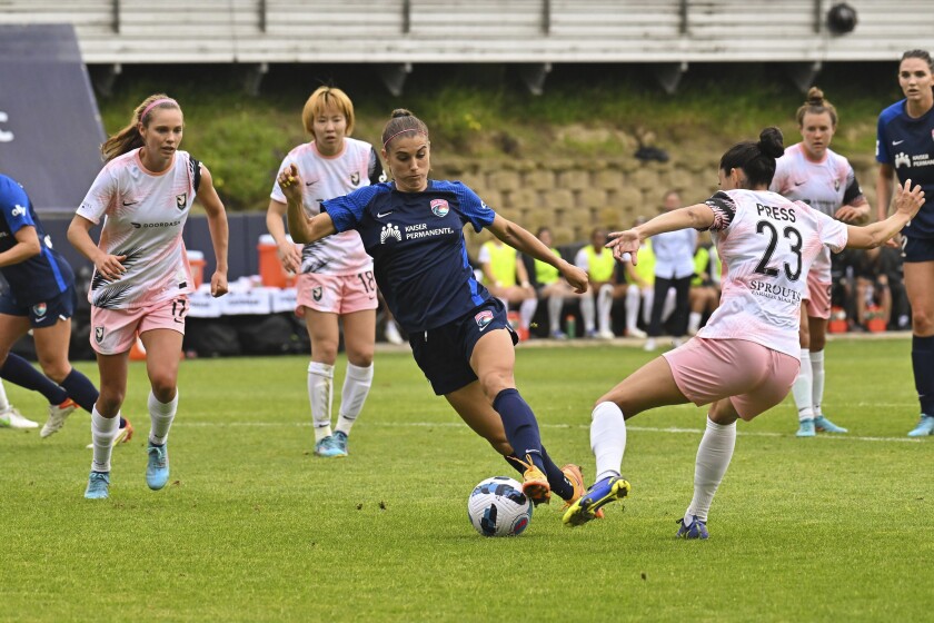 San Diego's Alex Morgan, middle, and Angel City's Christen Press (23) during a match in April.